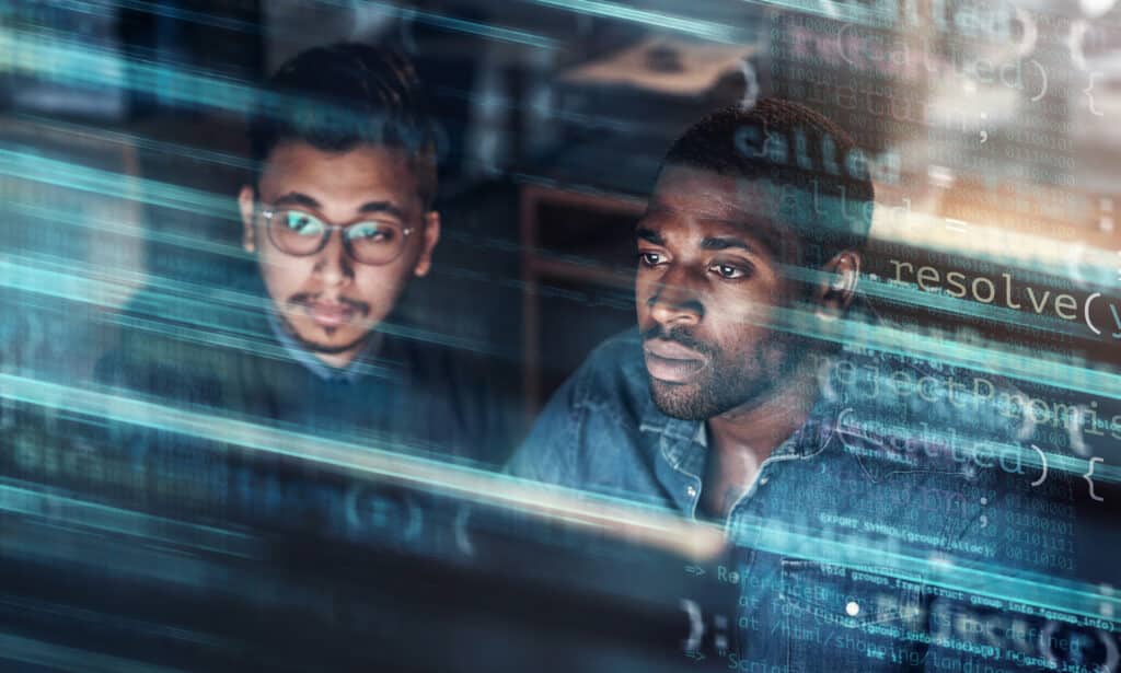Digitally enhanced shot of two handsome businessmen working in the office superimposed over multiple lines of computer code